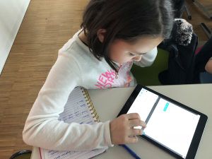 Schülerin mit iPad und Schreibzeug